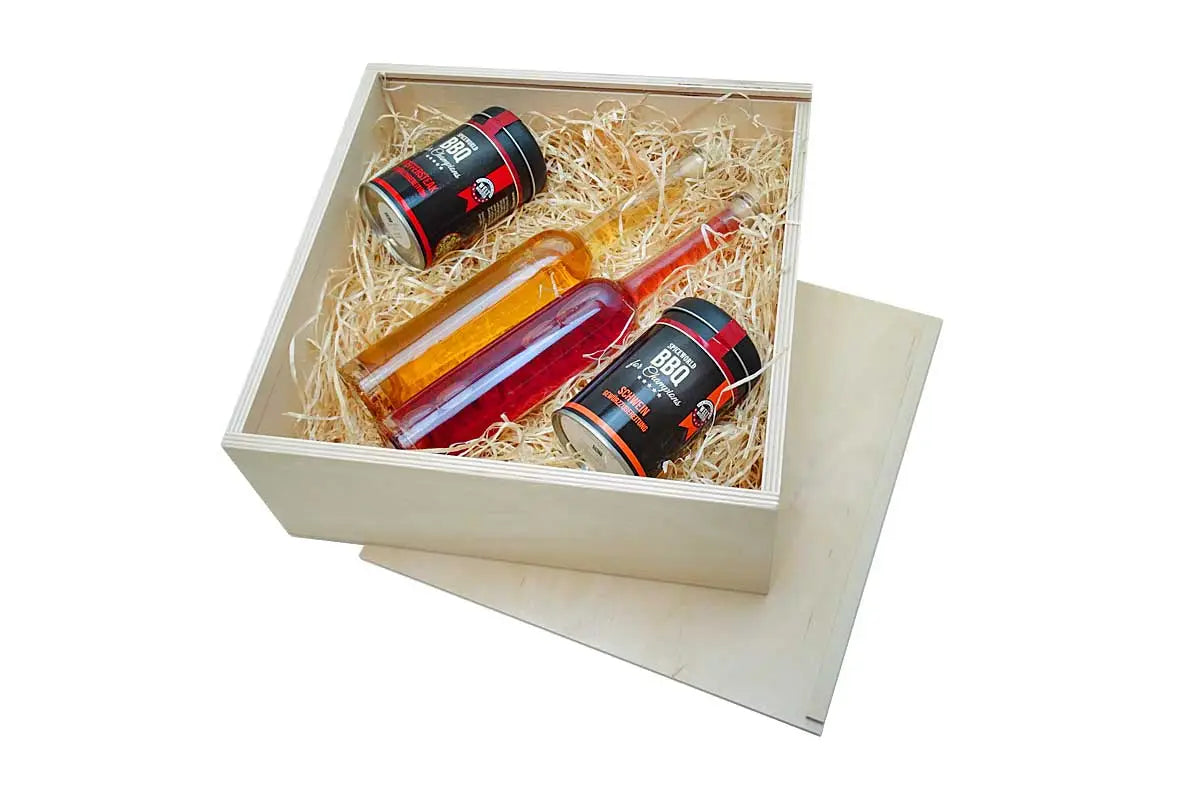 Hellfarbene genussbox aus holz mit schiebedeckel enthält zwei glasflaschen und zwei dosen in stroheinsatz