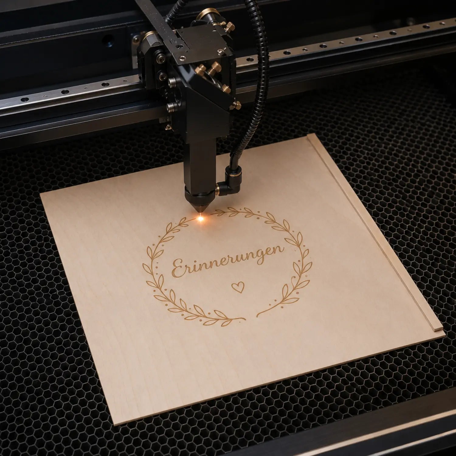 Lasergravurmaschine graviert goldenes kranzdesign mit erinnerungen und herz auf helles holz genussbox schiebedeckel